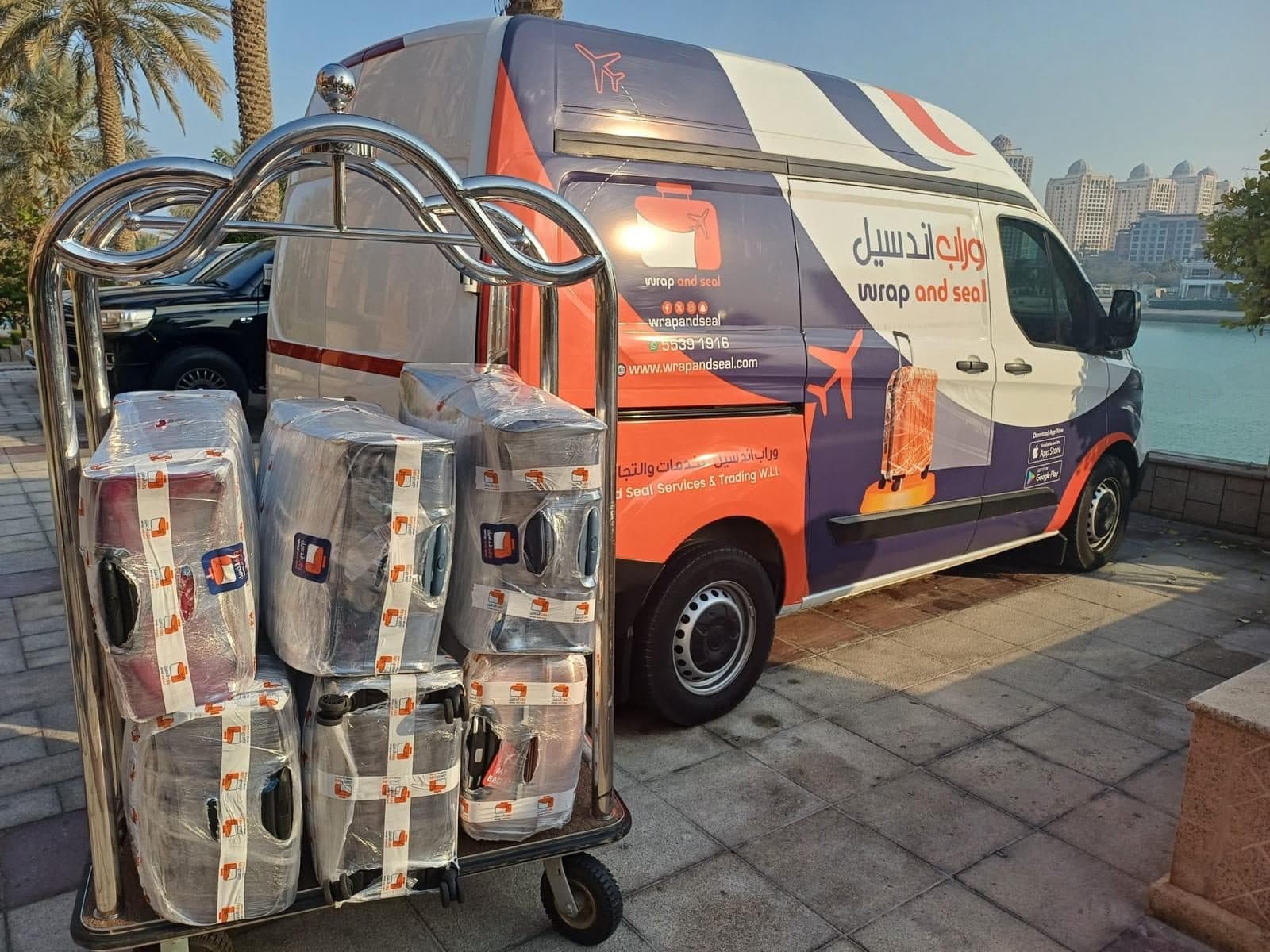 Wrapped luggage on a trolley beside the Wrap and Seal van